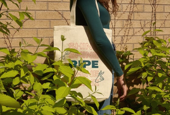 woman carries ripe branded tote bag